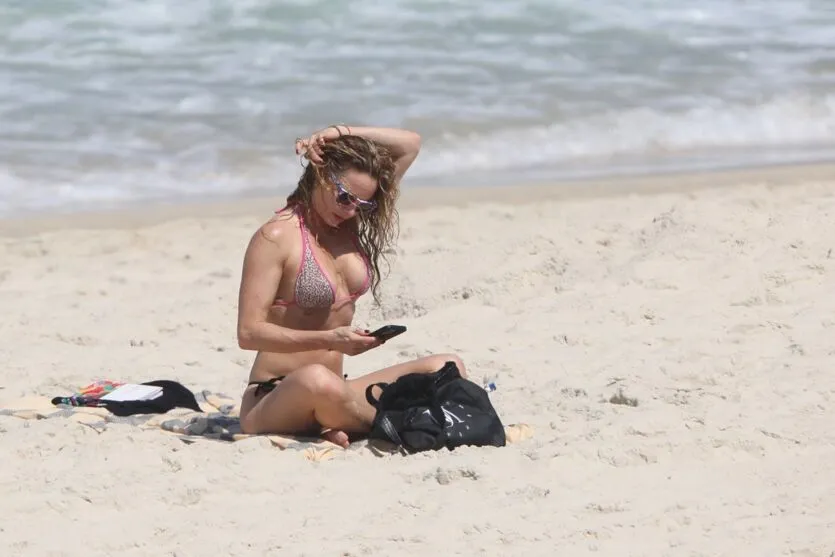 Rita Guedes atrai muitos olhares na praia ao exibir corpão
